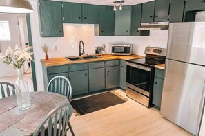 Seamless living spaces converge! Experience the perfect blend of dining and kitchen areas in one captivating view.