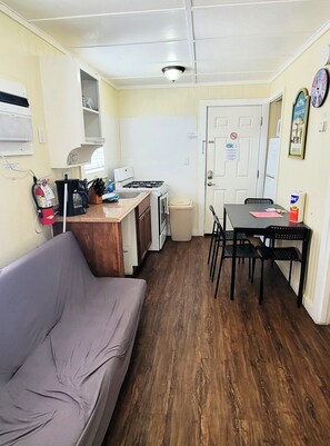 The living area has a futon, dining table that seats four, and a kitchenette