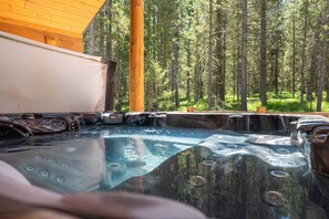Unwind in the private hot tub, surrounded by towering pines and fresh mountain air—the perfect way to relax after a day of Yellowstone adventures.