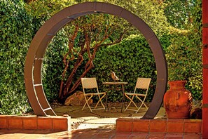 Peaceful Garden Nook with Artistic Arch and Cozy seating 