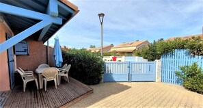 Terrasse extérieure du logement avec portail et vue sur la placette.