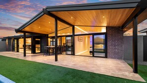 Modern covered patio with wood plank ceiling, dark beams, and seamless flow.