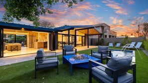 Stylish patio with a fire pit, modern seating, and seamless indoor-outdoor flow.