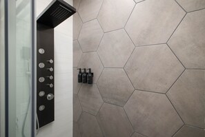 A luxurious rainfall and multi-jet spa shower adorn this modern bathroom