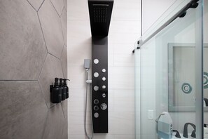 A luxurious rainfall and multi-jet spa shower adorn this modern bathroom