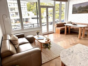Living and dining space featuring leather two seat lounge and marble breakfast bar.  Solid Oak parquetry throughout 