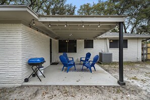 Step into relaxation on this inviting covered patio featuring a fire pit, perfect for enjoying a delicious BBQ with friends and family.