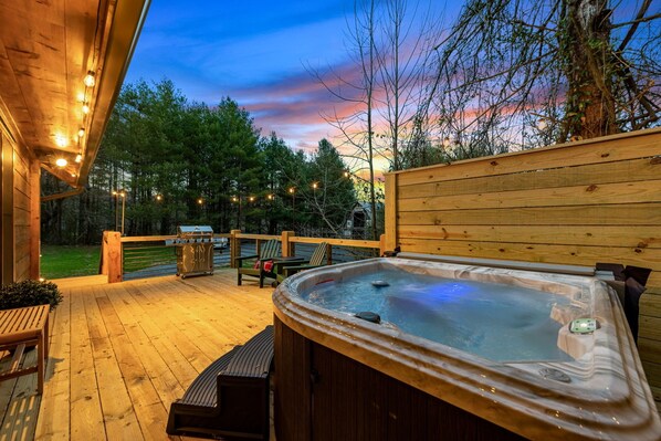 Soak in our secluded hot tub surrounded by the warm glow of string lights and the tranquil evening sky.