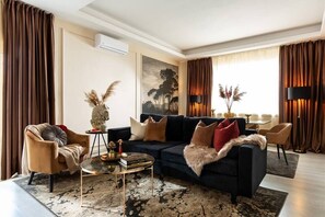 Enter our luxe living and dining area, where bold black, red, and gold accents mingle with natural light and the soft charm of pampas flowers."