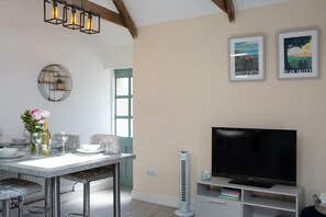 TV on storage cupboard. A frame beams