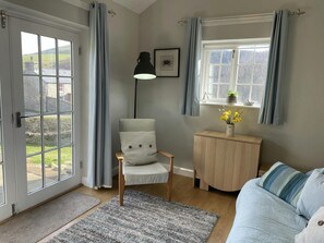 Sitting room with sofa, double french doors leading to garden
