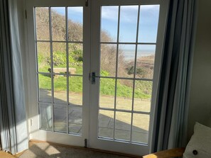 View of the garden and sea view through French doors in the living room