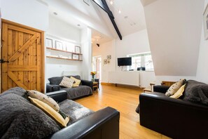 Wooden floor with comfortable seating and wall mounted TV