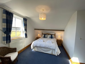 Double bed, bedside tables, lamps, chair and radiator