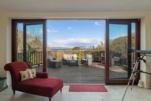 Armchair and telescope leading to terrace with patio furniture
