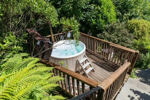 Steps leading from the terrace to a deck with hot tub on