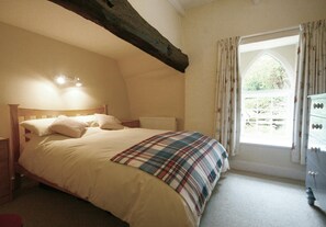 Bedroom with double bed, bedside drawers, chest of drawers, wooden beam