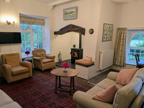 Living room with two sofas, two armchairs and double aspect windows