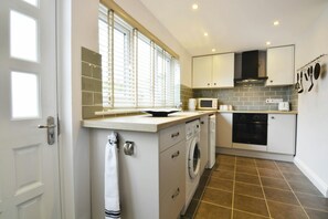 Kitchen with cooker, cooker hood, sink, washing machine