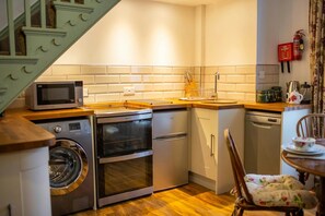 Electric hob and oven. Washing machine. Base cupboards  with wooden work surface