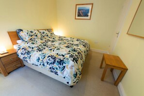 Super king bed with bedside table and lamps. Wall mounted mirror
