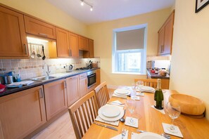 Kitchen with wall and base cupboards. Electric cooker and extractor hood