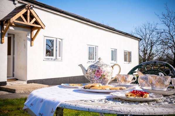 Outside view of Pen Y Graig Cottage, outdoor table with tea pot