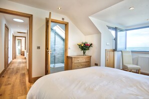 View over foot of double bed to open window and doors to en suite shower room and landing