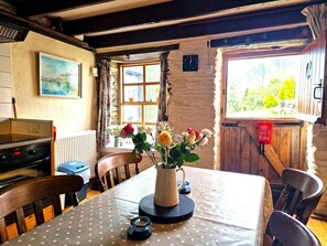 dining table to seat 4, with fresh flowers in a vase in the centre of table