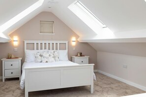 Double bed, bedside cabinets and lamps, sloping roof
