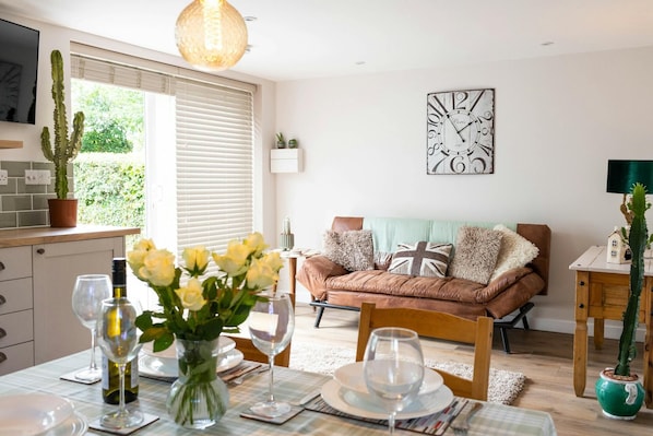 Table ready for lunch, vase of flowers, sofa, large clock