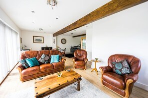 Living room with leather sofa set, coffee table and floor rug.