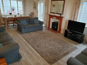 Lounge and dining area with sofas, tv, dining table and chairs, fireplace