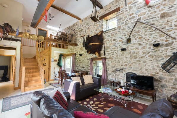 Living area with vaulted ceiling, tv, staircase