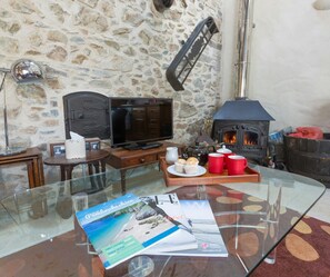 Living area with coffee table, tv and wood burner