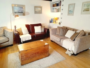 Lounge with two sofas, chest used as coffee table, standard lamp and bookcase