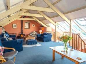 Living area with, sofas, log burner, armchair, beamed ceiling