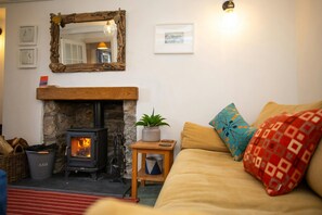 Sitting room with wood burner and wall mounted mirror above