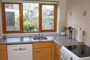 Dishwasher and kitchen sink. Window looking into the rear patio area