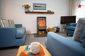 Wood burner with a wooden mantle shelf above and log store below