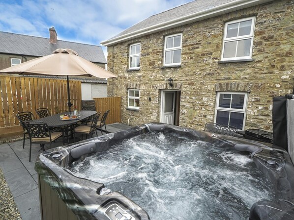 Hot tub  with parasol, patio table, and 6 chairs