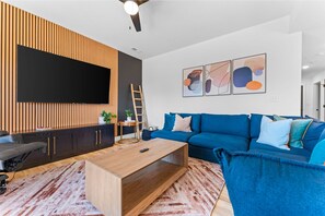 Additional Family Room with massive smart TV and comfortable sectional seating is in the lower level along with a massaging recliner