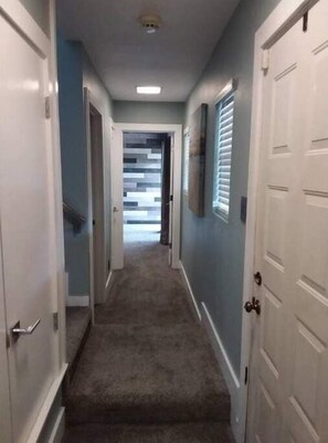 Downstairs hallway leading to staircase, hall bath and large guest room