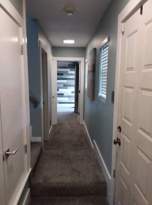 Downstairs hallway leading to staircase, hall bath and large guest room