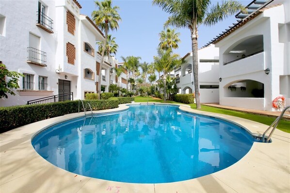 Inviting communal swimming pool surrounded by gardens