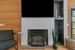 Large television above fireplace. Netflix and Sling included.