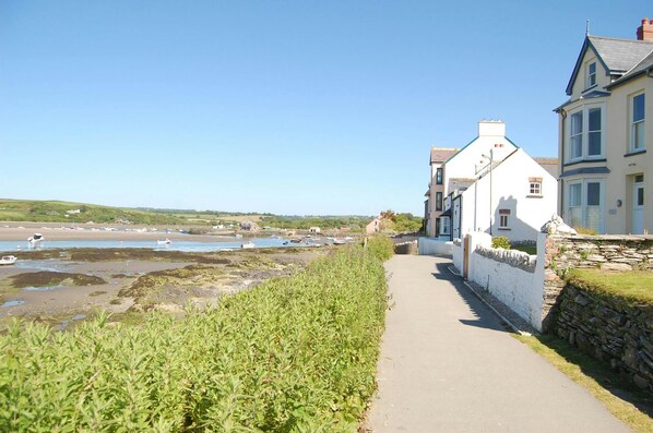View of coastal path with houses on the right and the sea and estuary to the left