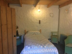 Single bed, bedside table with lamp, chair.