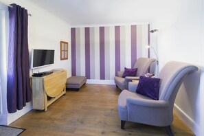 Living area with armchairs, tv, table