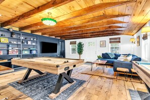 The “butcher shop” game room with air hockey, couch, shuffleboard, TV, & games. 